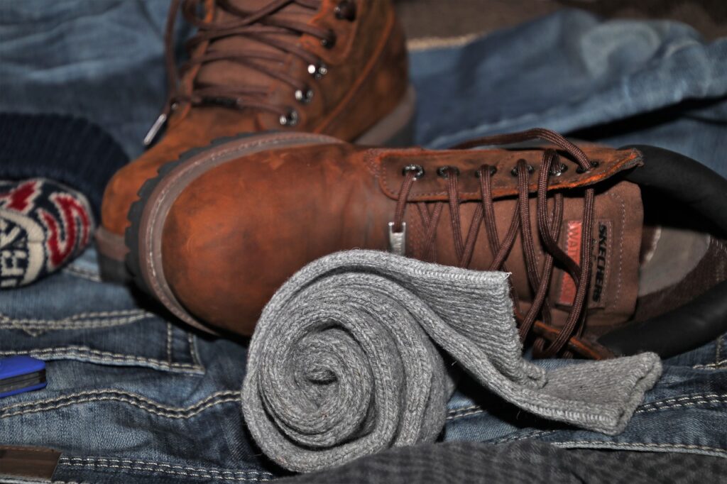 A picture of a pair of brown boots, socks and blue jeans