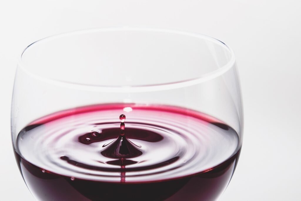A close of red wine on white background.